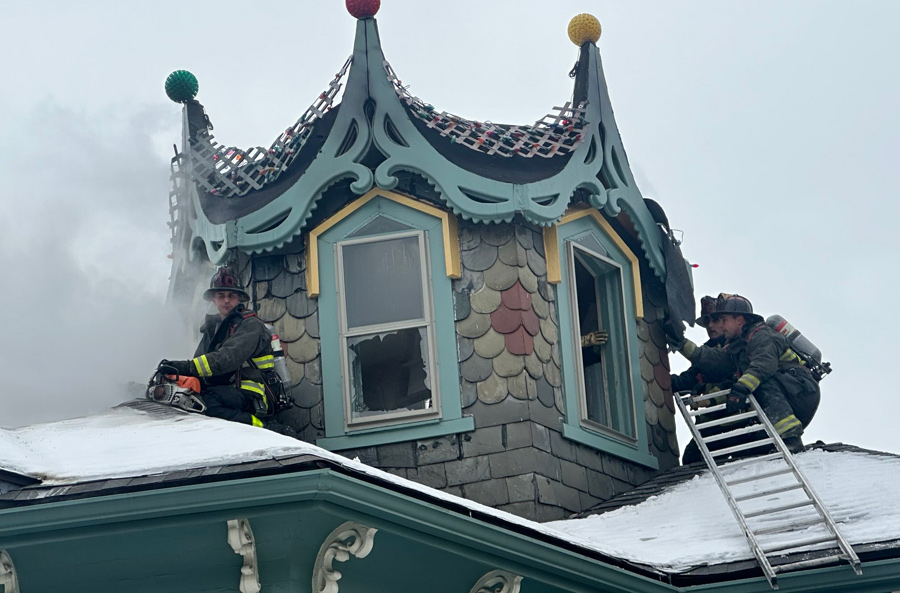 Firefighters at the top of a house with an octagonal top