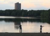 Two people fishing at Jamaica Pond at twilight