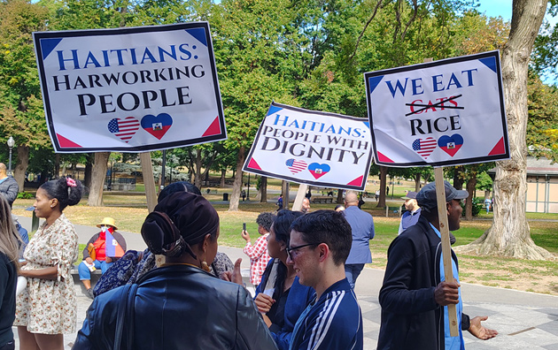 Signs that included one stating Haitians eat rice, not cats